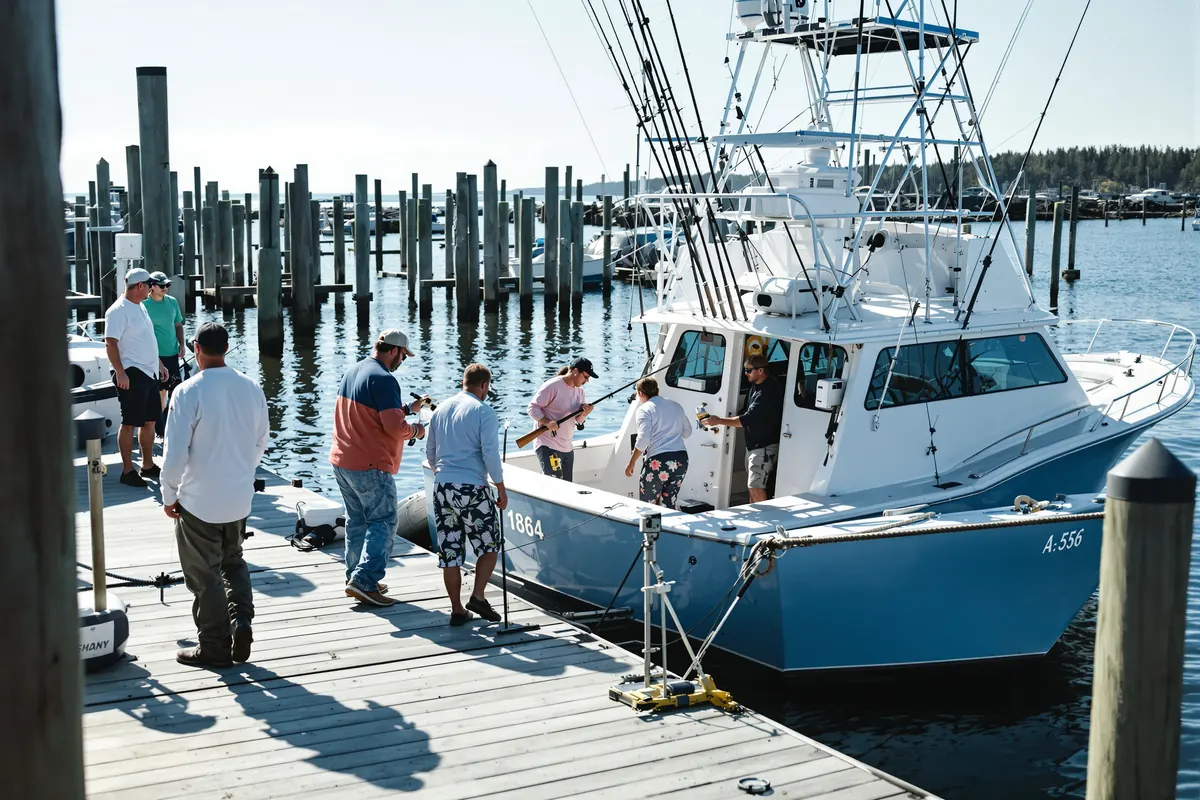 Group of anglers boarding a larger inspected charter boat at the dock